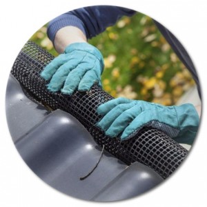 A Red Diamond Roofing crew member installing a leaf filter gutter guard on a home.