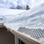 Ice dam in gutter and ice frozen on roof in winter