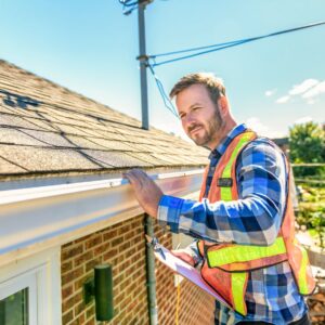 Roof inspector inspecting fascia on a home