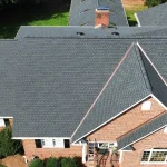 Aerial view of completed residential roof replacement with dark gray asphalt shingles on Colorado home